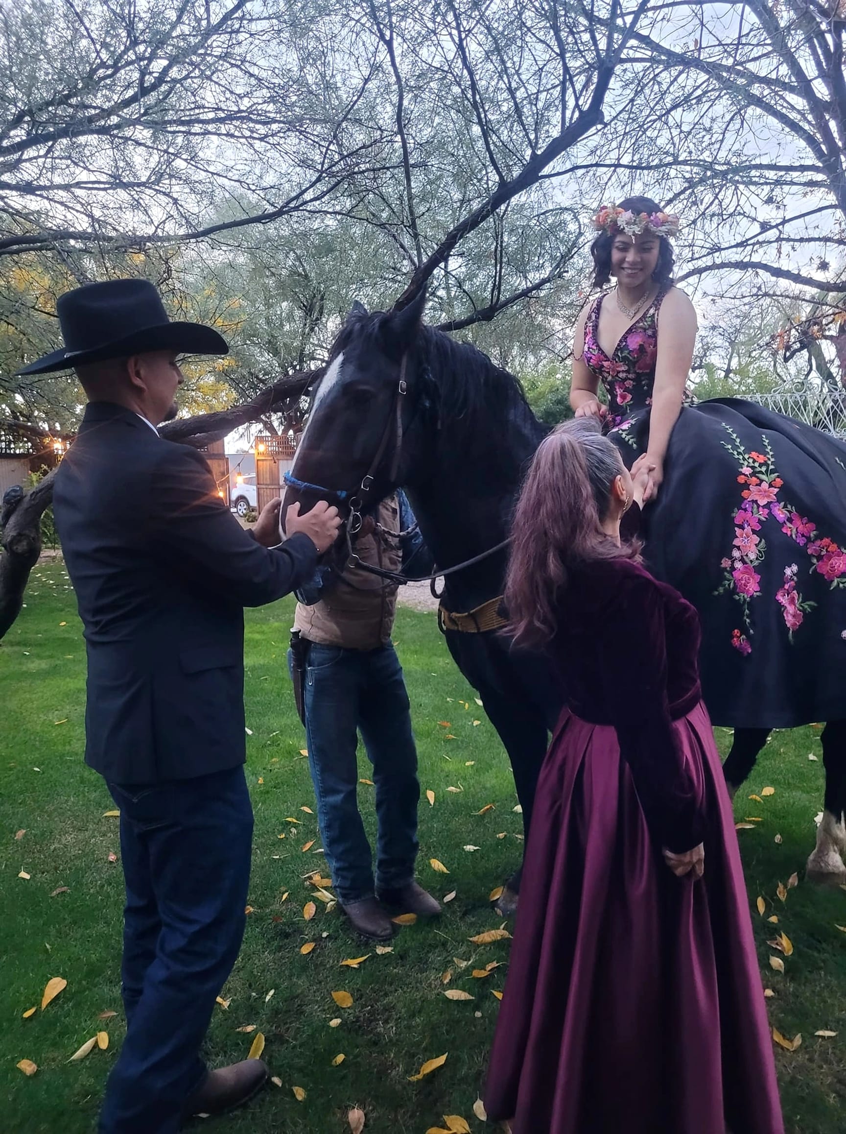 A couple with a black horse on the ranch.