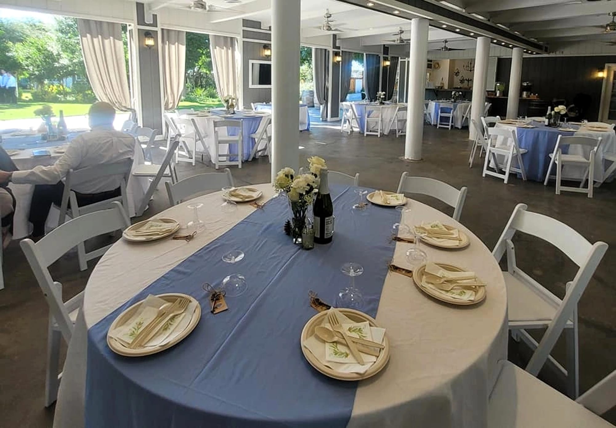 Reception tables laid under the covered ramada.